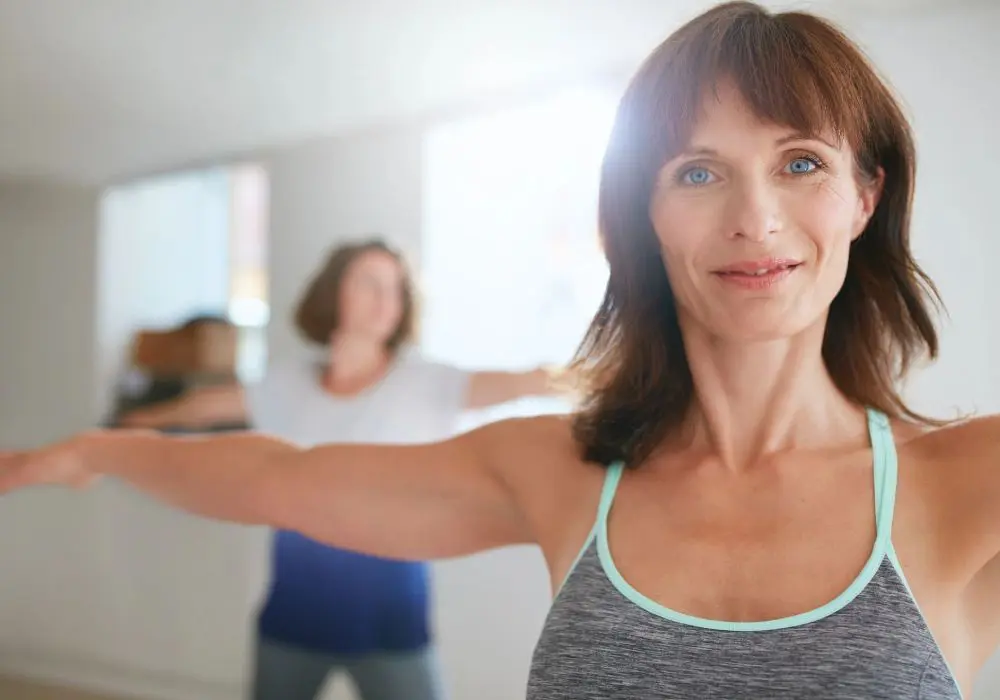 A woman is doing yoga in front of another person.