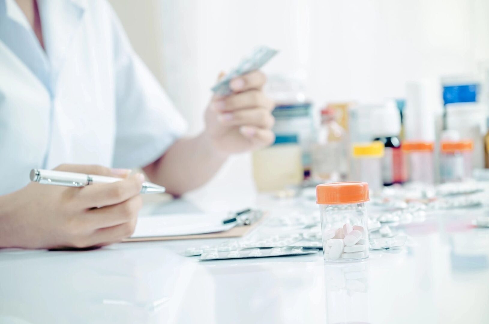 A person sitting at a table with some papers and a cell phone