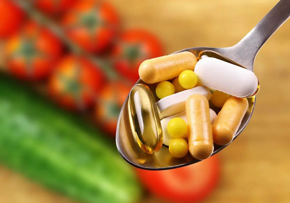 A spoon filled with pills and vegetables on top of a table.